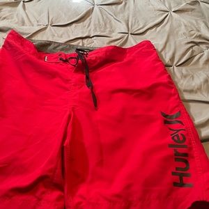 HURLEY MENS RED & BLACK SWIMMING TRUNKS. SIZE 36